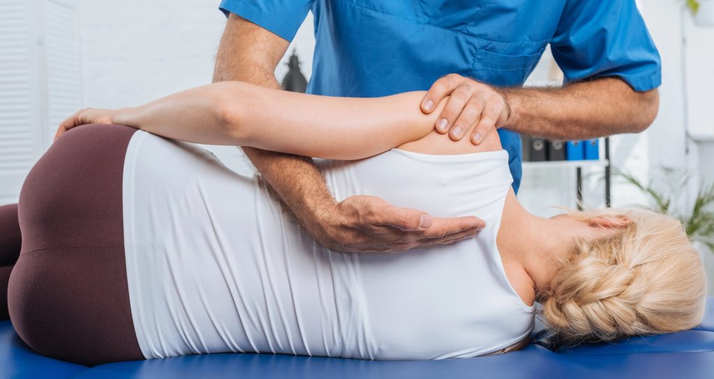 Chiropractor adjusting a woman's back - featured image for What to Expect at Your First Chiropractic Appointment