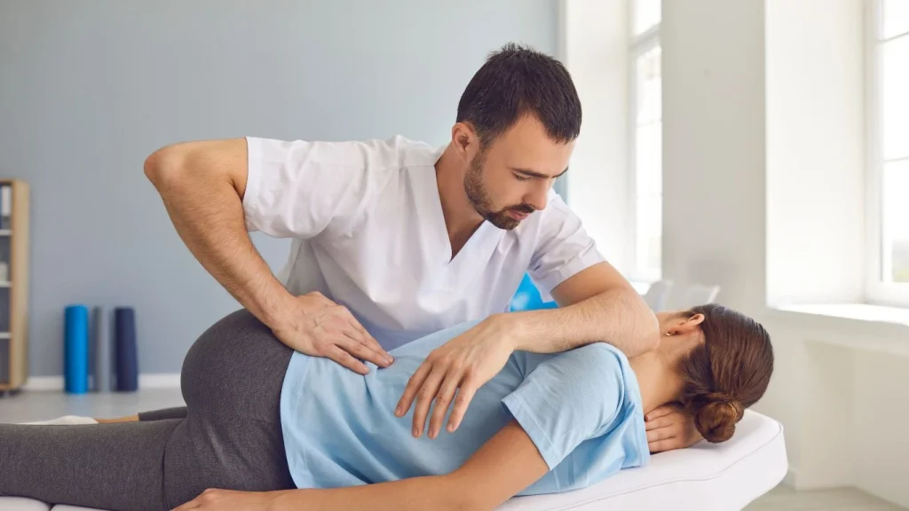 Chiropractor performing spinal adjustment on a patient during their first chiropractic appointment.